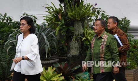 Menko Perekonomian Darmin Nasution (tengah) bersama Menteri Keuangan Sri Mulyani (kiri) dan Gubernur Bank Indonesia Perry Warjiyo bergegas seusai mengikuti rapat terbatas di Kompleks Istana Kepresidenan, Jakarta, Rabu (31/10/2018).