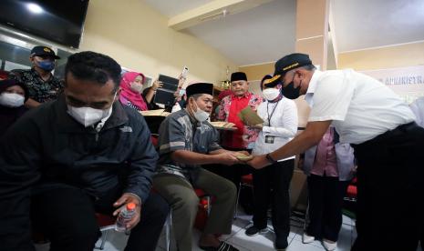 Menko PMK Muhadjir Effendi (kanan) menyerahkan bansos kepada keluarga korban meninggal tragedi Kanjuruhan di Kantor Kecamatan Lowokwaru, Kota Malang, Jawa Timur, Senin (3/10/2022). Mensos Tri Rismaharini bersama Menko PMK Muhadjir Effendi dan Wakil Ketua MPR Ahmad Basarah menyampaikan belasungkawa sekaligus menyerahkan secara langsung bansos berupa uang tunai dan sembako kepada sejumlah keluarga korban tragedi Kanjuruhan di wilayah tersebut. 