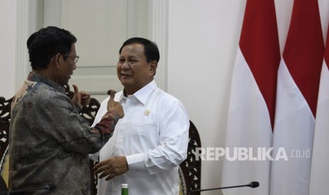 Menko Polhukam Mahfud MD (kiri) berbincang dengan Menteri Pertahanan Prabowo Subianto (kanan). (ilustrasi)