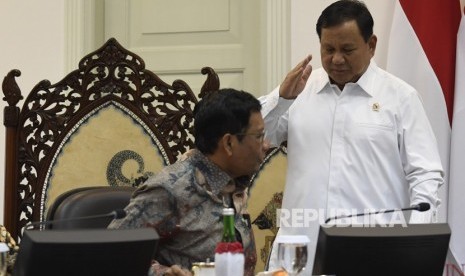 Menko Polhukam Mahfud MD (kiri) berbincang dengan Menteri Pertahanan Prabowo Subianto (kanan) saat akan mengikuti rapat terbatas tentang program dan kegiatan bidang politik, hukum dan keamanan di Kantor Presiden, Jakarta, Kamis (31/10/2019).