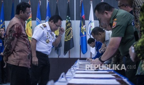 Menko Polhukam Mahfud MD (kiri) bersama Kepala Badan Keamanan Laut (Bakamla) Laksamana Madya TNI Aan Kurnia (kedua kiri) menyaksikan penandatanganan kesepakatan bersama pengawasan, pengamanan, dan pemanfaatan sumber daya ikan Laut Natuna Utara oleh sejumlah perwakilan institusi, perusahaan dan asosiasi, di Mabes Bakamla, Jakarta, Jumat beberapa waktu lalu.