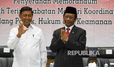 Menko Polhukam Mahfud MD (kiri) bersama mantan Menko Polhukam Wiranto (kanan) mengikuti serah terima jabatan di kantor Kemenko Polhukam, Jakarta, Rabu (23/10/2019).