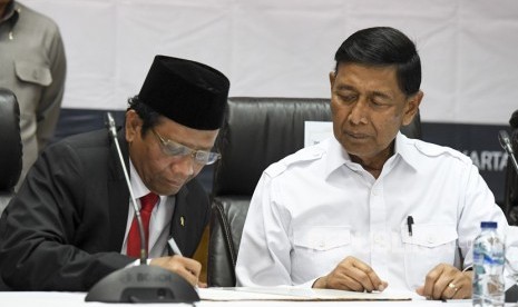 Menko Polhukam Mahfud MD (kiri) bersama mantan Menko Polhukam Wiranto menandatangani berita acara serah terima jabatan di kantor Kemenko Polhukam, Jakarta, Rabu (23/10/2019). 