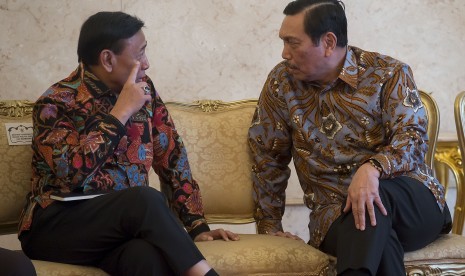 Menko Polhukam Wiranto (kiri) berbincang dengan Menko Maritim dan Sumber Daya Luhut Pandjaitan (kanan) sebelum mengikuti acara peluncuran Strategi Nasional Keuangan Inklusif di Istana Negara, Jakarta, Jumat (18/11). 