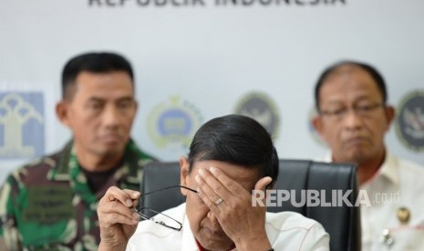 Menko Polhukam Wiranto (tengah) mengusap wajahnya saat memberikan keterangan pers di Kemenko Polhukam, Jakarta, Kamis (26/9/2019).