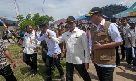 Menkopolhukam Wiranto (kedua kanan) berbincang dengan Kepala BNPB Letjen TNI Doni Monardo (kanan) saat mengunjungi pengungsi korban bencana di kompleks Hunian Sementara (Huntara) Desa Mpanau, Sigi, Sulawesi Tengah, Senin (1/7/2019).