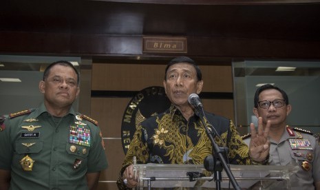 Menkopolhukam Wiranto (tengah) didampingi Panglima TNI Jenderal TNI Gatot Nurmantyo (kiri) dan Kapolri Jenderal Pol Tito Karnavian (kanan) memberikan keterangan pers usai rapat tertutup terkait pembelian senjata api di Kemenko Polhukam, Jakarta, Jumat (6/10).