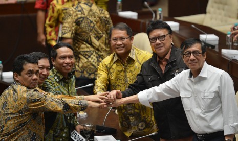 Menkumham Yasonna Laoly (kanan), Mendagri Tjahjo Kumolo (kedua kanan), Menkominfo Rudiantara (ketiga kanan), Ketua Komisi II DPR Zainudin Amali (ketiga kiri), Wakil Ketua Fandi Utomo (kedua kiri) dan Ahmad Riza Patria saling bertumpu tangan seusai rapat kerja di Kompleks Parlemen, Senayan, Jakarta, Jumat (20/10). 