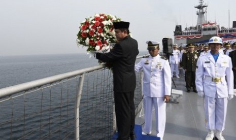 MenPAN RB Yuddy Chrisnandi bersiap melemparkan karangan bunga ke laut dalam upacara peringatan Hari Pahlawan di atas kapal perang KRI Banda Aceh di perairan Teluk Jakarta, Selasa (10/11). 