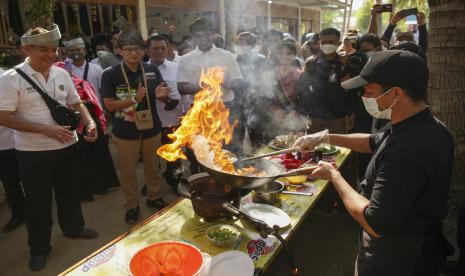 Menparekraf Sandiaga Uno (kedua kiri) menyaksikan proses memasak makanan khas melayu saat kunjungannya di desa wisata Bakau Serip, Batam, Kepulauan Riau, Selasa (31/5/2022). 