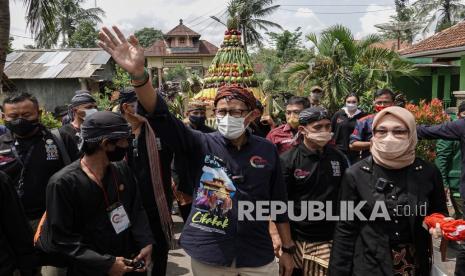 Menparekraf Sandiaga Uno (tengah) mengikuti kirab gunungan yang terbuat dari buah-buahan untuk memberi makan kera liar pada Festival Rewanda Bojana di Desa Cikakak, Wangon, Banyumas, Jateng, Rabu (13/10/2021). Sandiaga Uno melakukan proses peninjauan dan penilaian langsung di Desa Cikakak, Banyumas, Jateng, yang masuk dalam 50 Besar Desa Wisata Terbaik pada Anugerah Desa Wisata Indonesia (ADWI) 2021.