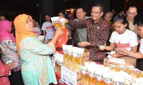  Menperin Saleh Husin (tengah) melayani pembeli minyak goreng pada Bazar Lebaran Tahun 2016 di Plasa Pameran Industri Kementerian Perindustrian, Jakarta, Selasa (21/6).