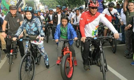 Menpora Imam Nahrawi (kanan) bersama istri (kiri) dan anak.