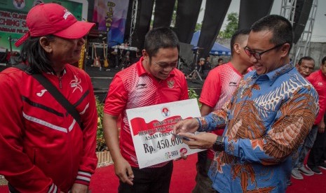 Menpora Imam Nahrawi (kanan) menyerahkan bonus secara simbolis kepada sejumlah pelatih Asian Para Games. 