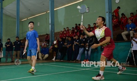 Menpora Imam Nahrawi (kanan) yang berpasangan dengan pebulu tangkis Kevin Sanjaya Sukamuljo (kiri) mengembalikan kok saat bertanding di sela-sela kunjungannya ke Sekolah Khusus Olahragawan (SKO) Ragunan di Jakarta, Selasa (27/3). 