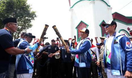 Menpora Imam Nahrawi (kedua kanan) didampingi Ketua Inapgoc Raja Sapta Oktohari (kanan) melakukan prosesi kirab obor (torch relay) Asian Para Games 2018 di Kedaton Kasultanan Ternate, Maluku Utara, Minggu (9/9).