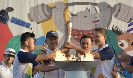 Menpora Imam Nahrawi (kedua kanan), Ketua DPR Bambang Soesatyo (kedua kiri), Pebulu tangkis Sony Dwi Kuncoro (kanan) dan penulis Arief Muhammad menyulut api obor saat pawai obor (torch relay) Asian Games 2018 di kawasan Garuda Wisnu Kencana (GWK), Badung, Bali, Selasa (24/7). 