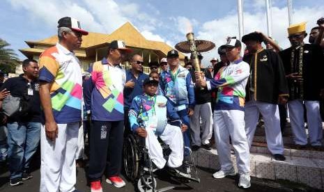 Menpora Imam Nahrawi (kedua kiri) didampingi Ketua Inapgoc Raja Sapta Oktohari (ketiga kanan) dan Wali Kota Ternate Burhan Abdurahman (kedua kiri) melakukan prosesi awal kirab obor (torch relay) Asian Para Games 2018 di Kedaton Kasultanan Ternate, Maluku Utara, Minggu (9/9). 