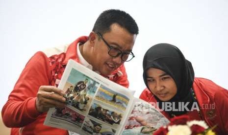 Menpora Imam Nahrawi (kiri) dan atlet Judo Indonesia Miftahul Jannah (kanan) berbincang-bincang saat konferensi pers di GBK Arena, Jakarta, Selasa (9/10).