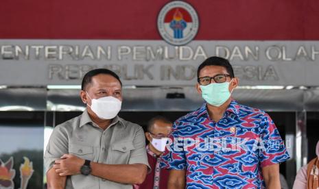 Menpora Zainudin Amali (kiri) berbincang dengan Menparekraf Sandiaga Salahuddin Uno (kanan) usai pertemuan membahas tentang kerjasama pengembangan 