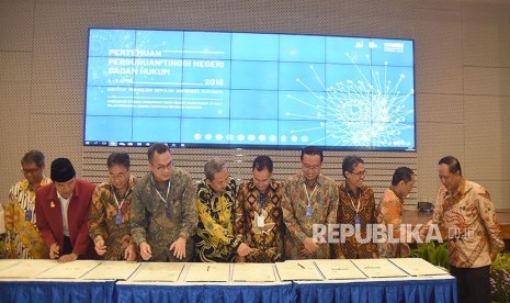 Menristekdikti Mohamad Nasir (kanan) menyaksikan sejumlah Rektor Perguruan Tinggi Negeri menandatangani nota kesepahaman di sela-sela Pertemuan Perguruan Tinggi Negeri Badan Hukum (PTN-BH) 2018 di Gedung Pusat Riset Institut Teknologi Sepuluh November (ITS), Surabaya, Jawa Timur, Rabu (4/4).