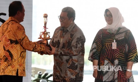 Menristekdikti Muhammad Nasir (kiri) memberikan piala penghargaan Anugerah Budhipura kepada Gubernur Jawa Barat Ahmad Heryawan (tengah) pada peringatan Hari Kebangkitan Teknologi Nasional (Hakteknas) ke-22 di Center Point Indonesia (CPI), Makassar, Sulawesi Selatan, Kamis (10/8). 