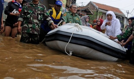 Mensos Khofifah Indar Parawansa (kanan) bersama Gubernur Provinsi Jawa Barat Ahmad Heryawan (keempat kiri) menaiki perahu saat meninjau sejumlah lokasi terdampak banjir di Desa Bojong Asih, Kabupaten Bandung, Jawa Barat, Senin (14/3).