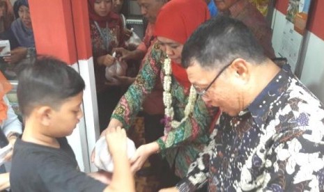 Mensos Khofifah Indar Parawansa membagikan telur untuk anak-anak di sela-sela persemian e-warong di Ngajuk, Ahad (9/4)