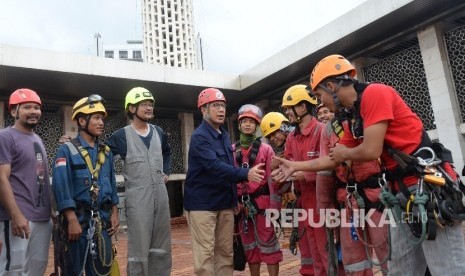 Menteri Agama Lukman Hakim Saifuddin berjabat tangan dengan para relawan saat meninjau proses membersihkan Masjid Istiqlal, Jakarta, Ahad (19/2). 