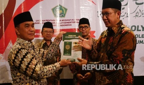  Menteri Agama Lukman Hakim Saifuddin (kanan) menyerahkan Manual Book Kemenag Qur’an Kemenag versi android kepada Imam Besar Masjid Agung Palembang Hanawi Dencik (kiri) sebagai tanda peluncuran aplikasi Quran Kemenag, di Jakarta, Selasa (30/8).