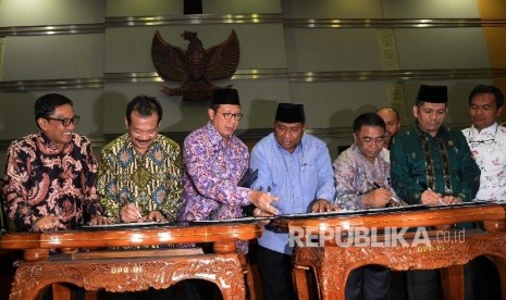  Menag Lukman Hakim Saifuddin (ketiga kiri), bersama Ketua Komisi VIII DPR Ali Taher Parasong (empat dari kanan), saat penetapan Biaya Penyelenggaraan Ibadah Haji (BPIH) di Kompleks Parlemen, Senayan, Jakarta, Jumat (24/3).