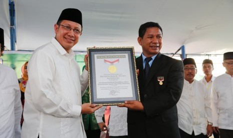 Menteri Agama, Lukman Hakim Saifuddin ketika menerima plakat Museum Rekor Indonesia untuk kategori Mengaji Massal di Palu. 