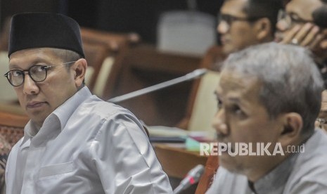 Menteri Agama Lukman Hakim Saifuddin (kiri) bersama Kepala Badan Pelaksana Badan Pengelola Keuangan Haji (BPKH) Anggito Abimanyu (kanan) mengikuti Raker dengan Komisi VIII DPR di Kompleks Parlemen Senayan, Jakarta, Kamis (24/5).