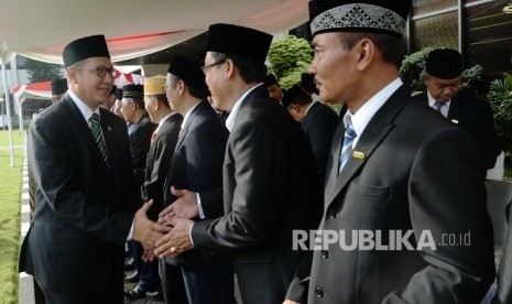 Menteri Agama Lumkman Hakim Syaifuddin bersalaman dengan jajaran deputi seusai menjadi inspektur upacara dalam rangka pelaksanaan Hari Amal Bakti (HAB) Kementerian Agama RI ke-71 di halaman Kemenag, Jakarta, Selasa (3/1).