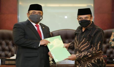 Menteri Agama Yaqut Cholil Qoumas (kiri) bertukar naskah dengan mantan Menteri Agama Fachrul Razi saat serah terima jabatan di Kantor Kemenag, Jakarta, Rabu (23/12/2020). Presiden melantik Yaqut Cholil Qoumas menjadi menteri agama menggantikan Fachrul Razi pada periode sisa masa jabatan 2019-2024.