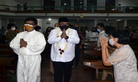 Menteri Agama Yaqut Cholil Qoumas (tengah) didampingi Pastor Kepala Paroki Gereja Katedral Kristus Raja Tanjungkarang Romo JB Sujanto (kiri) menyapa jemaat saat berkunjung ke Gereja Katedral Kristus Raja Tanjungkarang usai Misa Malam Natal di Bandar Lampung, Lampung, Jumat (24/12/2021). Dalam kunjungannya Menteri Agama Yaqut Cholil Qoumas mengucapkan selamat Natal tahun 2021 dan selamat menyongsong Tahun baru 2022 kepada seluruh umat Nasrani serta mengajak untuk menjadikan peringatan Natal tahun ini sebagai momentum memperkuat persaudaraan.