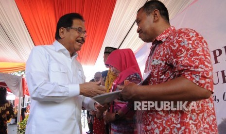 Menteri Agraria dan Tata Ruang/Badan Pertanahan Nasional (ATR/BPN) Sofyan Djalil (kiri) menyerahkan sertifikat tanah kepada masyarakat saat penyerahan sertifikat konsolidasi tanah untuk rakyat di Salatiga, Jawa Tengah, Jumat (6/12/2019).