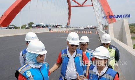 Menteri Badan Usaha Milik Negara (BUMN) Rini Soemarno (kanan) didampingi Direktur Utama PT. Jasa Marga Desi Arryani (kiri) dan Direktur Utama Waskita Karya I Ketut Ngurah Putra (tengah) berbincang saat Ekspedisi Tembus Tol Trans Jawa di Jembatan Kalikuto, Kabupaten Batang, Jawa Tengah, Senin (12/11/2018).