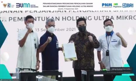 Menteri BUMN Erick Thohir (kedua dari kanan), Dirut Pegadaian Kuswiyoto (kiri), Dirut BRI Sunarso (kedua dari kiri), dan Dirut PNM Arief Mulyadi (kanan) saat penandatangan perjanjian pengalihan saham dalam rangka pembentukan Holding Ultramikro di Jakarta, Senin (13/9).