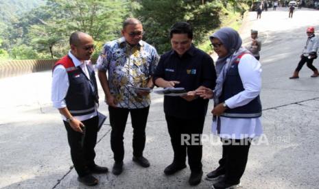 Menteri BUMN Erick Thohir (kedua kanan) didampingi anggota DPR Andre Rosiade (kedua kiri) dan Direktur Operasional Hutama Karya Agung Fajarwanto (kiri) serta Direktur PT Hutama Karya Infrastruktur Aji Prasetyanti (kanan) memperlihatkan site plan pembangunan Flyover Sitinjau Lauik di Padang, Sumatera Barat, Selasa (20/12/2022). Pembangunan jalan layang yang ditargetkan dimulai pada 2023 tersebut diharapkan dapat mengurai kemacetan lalu lintas di jalur tersebut  sekaligus untuk memajukan sektor pariwisata di Sumatera Barat. 