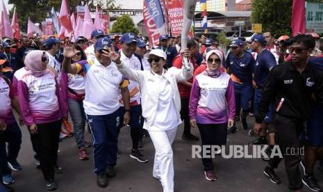 Menteri BUMN Rini M. Soemarno (tengah) membawa obor saat prosesi Torch Relay Asian Games (AG) 2018 melintasi Jalan Cut Nyak Dien Bandar Lampung, Lampung, Rabu (8/8). 