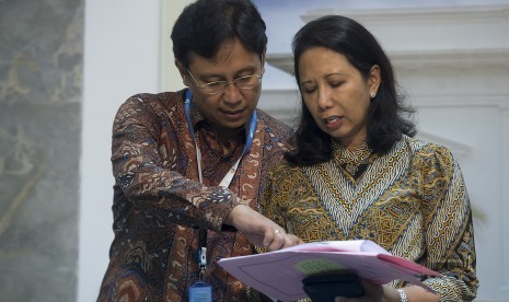 Menteri BUMN Rini Soemarno (kanan) berbincang dengan staf khususnya Budi Gunadi Sadikin (kiri) sebelum memberikan keterangan pers hasil rapat kabinet terbatas di Kantor Kepresidenan, Jakarta, Jumat (12/8).