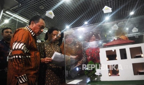 Menteri BUMN Rini Soemarno (kedua kiri), Dirut Bank BTN Maryono (kiri) melihat pameran perumahan saat perayaan HUT Kredit Kepemilikan Rumah (KPR) ke 40 tahun di Jakarta, Selasa (13\12).