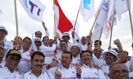 Menteri BUMN Rini Soemarno (tengah) didampingi Direktur Utama Garuda Indonesia Arif Wibowo dan sejumlah direksi BUMN mengibarkan bendera di Bukit Merese Tanjung Aan, Lombok, NTB, Jumat (27/1). 