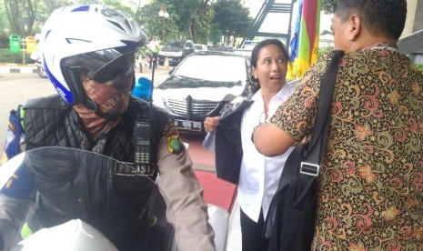 Menteri BUMN Rini Soemarno (tengah) melepas jaket usai diantar dengan sepeda motor patwal ketika menuju Kantor Menko Perekonomian, Jumat (4/11).