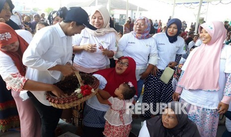 Menteri BUMN Rini Sumarno, diserbu petani dan warga Desa Lemah Duhur, Kecamatan Tempuran, Karawang, saat membagikan telor asin batik, Kamis (19/4). 