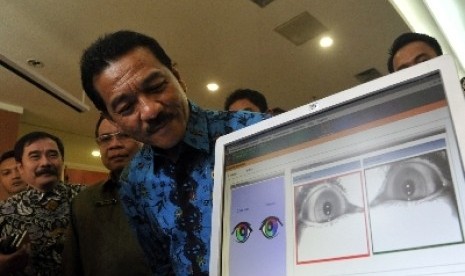 Menteri Dalam Negeri Gamawan Fauzi mengecek data e-KTP miliknya dengan sistem pemindaian iris mata di Kementerian Dalam Negeri, Jakarta Pusat.