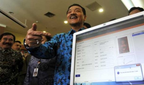 Menteri Dalam Negeri Gamawan Fauzi (tengah) tersenyum seusai memindai data e-KTP miliknya di Kementerian Dalam Negeri, Jakarta Pusat, Kamis (8/11).