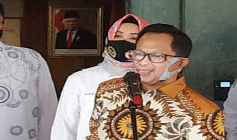 Menteri Dalam Negeri (Mendagri) Tito Karnavian memakai masker menyerupai wajahnya saat konferensi pers dengan Satgas Lawan Covid-19 DPR di Kantor Kemendagri, Jakarta, Kamis (28/5). 