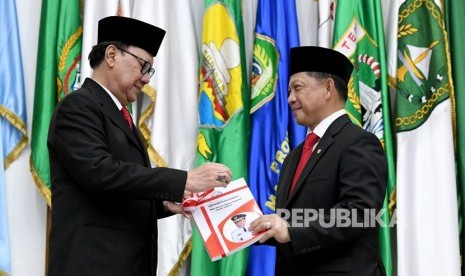 Menteri Dalam Negeri Tito Karnavian (kanan) menerima memori serah terima jabatan dari pejabat lama Tjahjo Kumolo (kiri) saat serah terima jabatan di Kantor Kemendagri, Jakarta, Rabu (23/10/2019). 